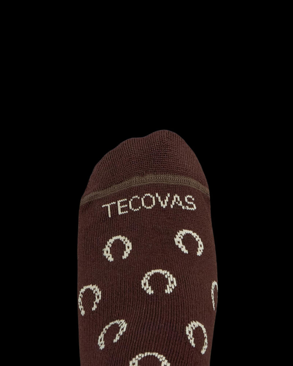 Brown sock with the word "Tecovas" and a pattern of light-colored horseshoes on the top, photographed against a white background.