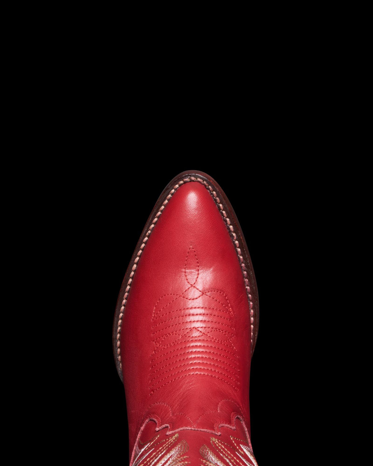 A crimson, pointed-toe cowboy boot, The Abby Wide Calf Cowhide, viewed from above on a plain white background.