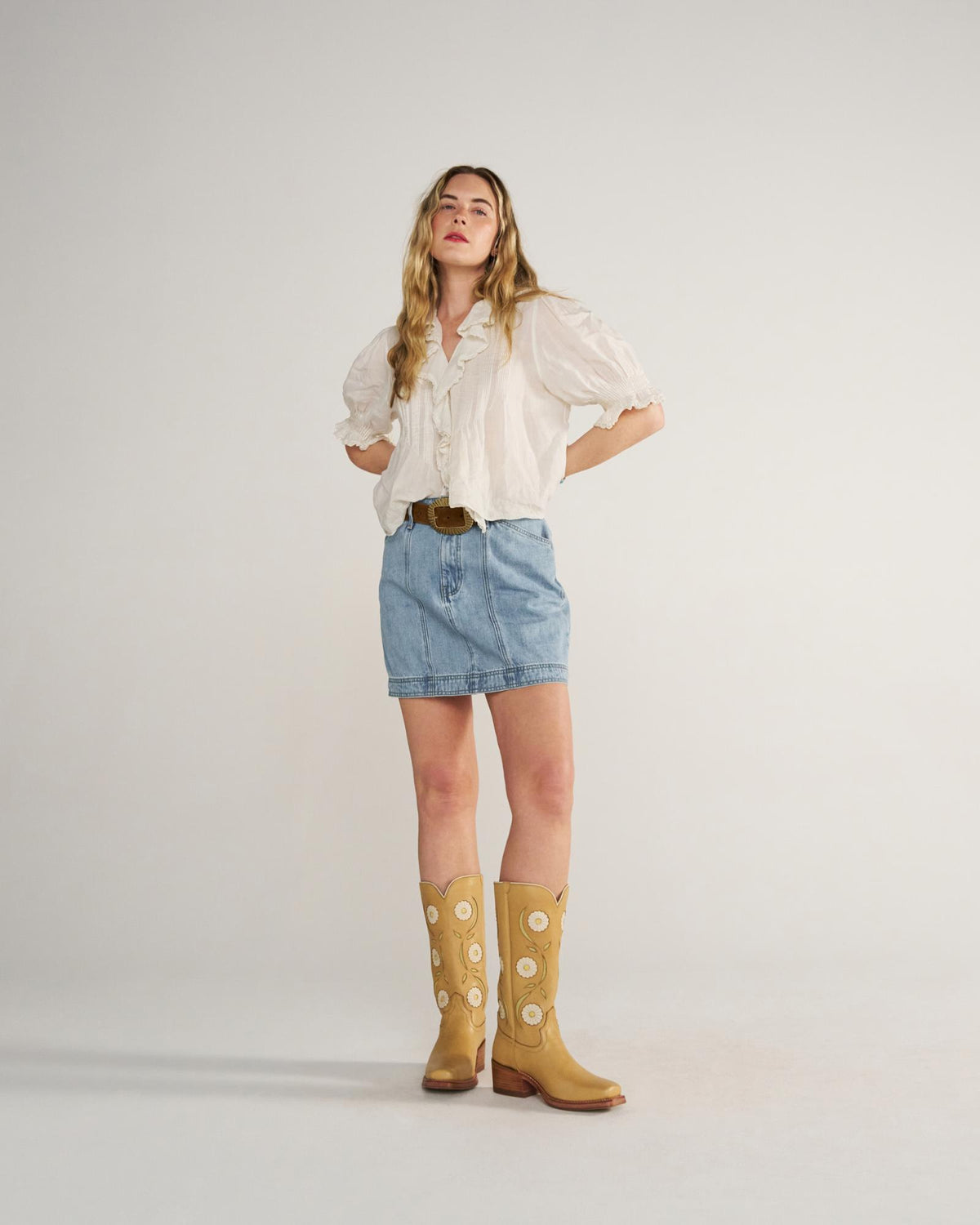 Full view of Women's High-Rise Denim Mini Skirt - Light Wash on model
