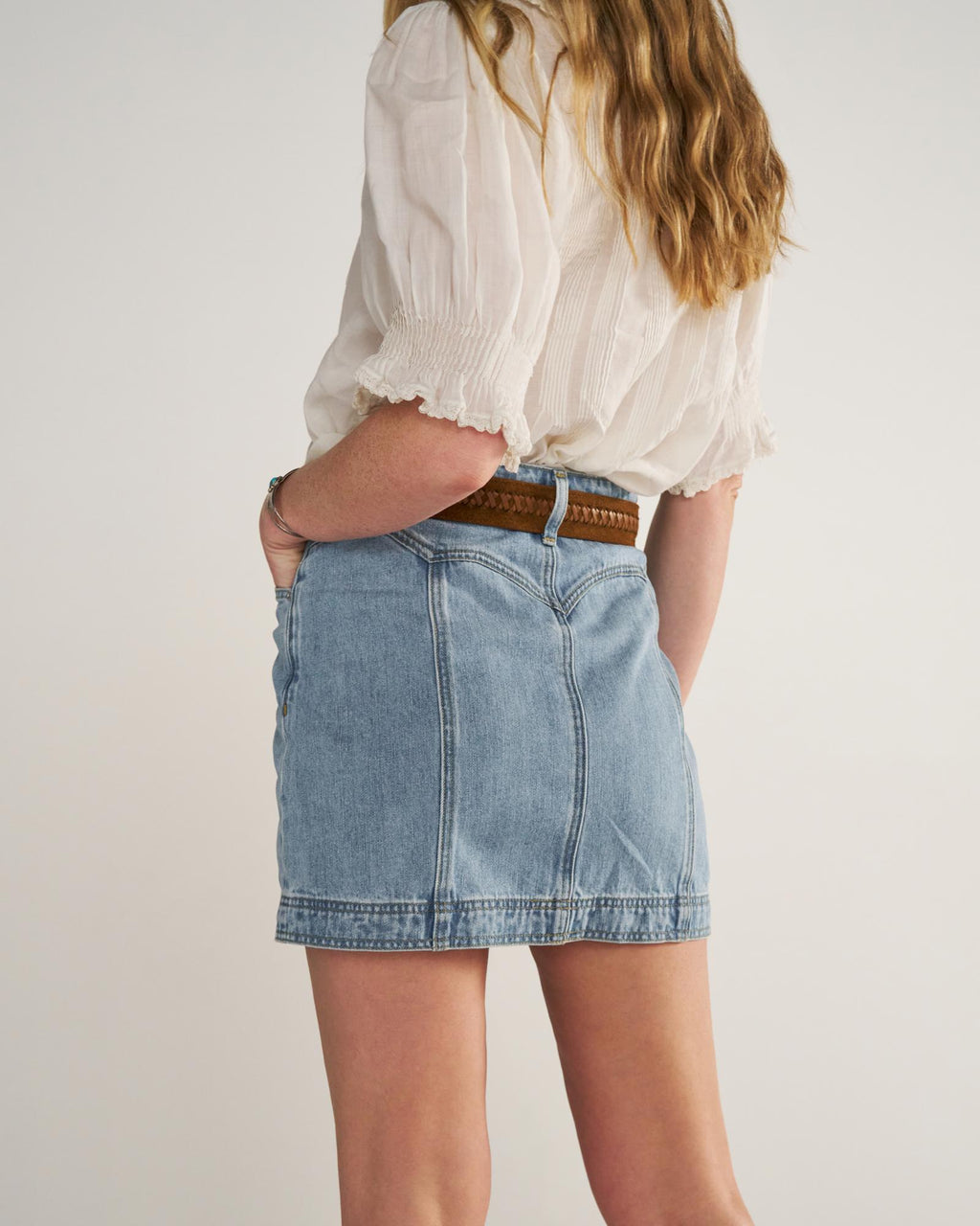 Back view of Women's High-Rise Denim Mini Skirt - Light Wash on model