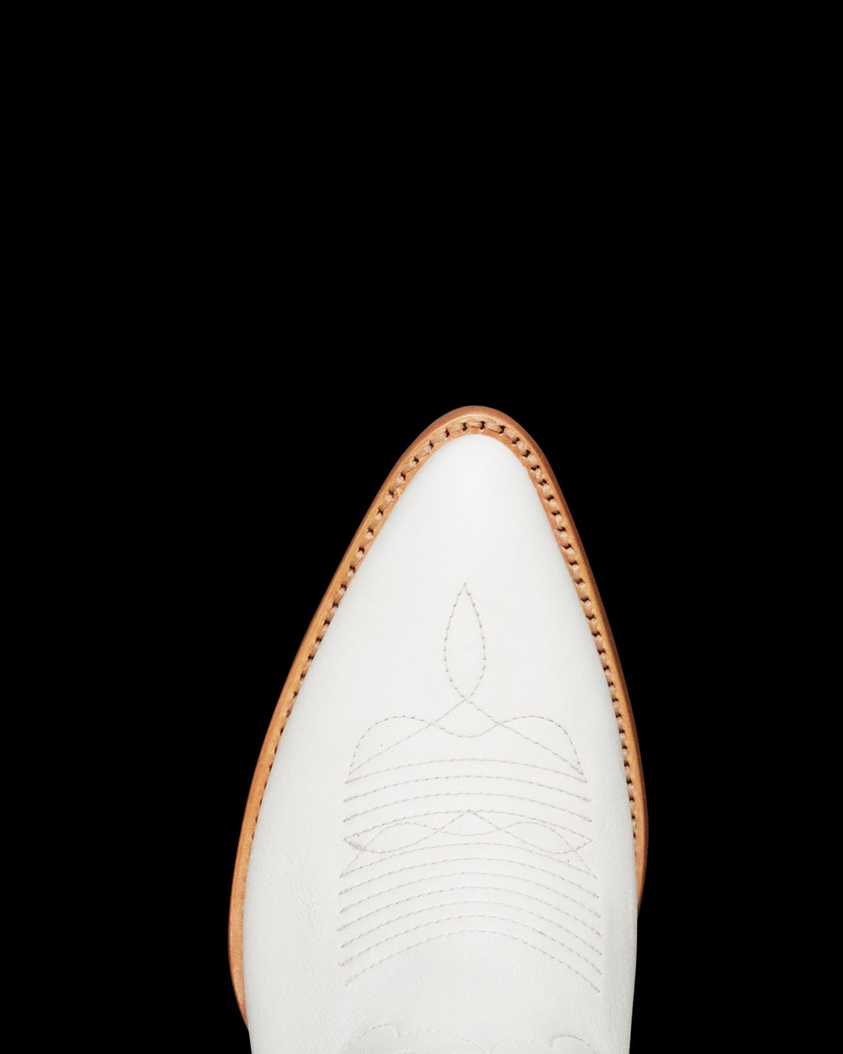 Top view of a white cowboy boot with decorative stitching and a pointed toe, set against a white background with shadow on the right.