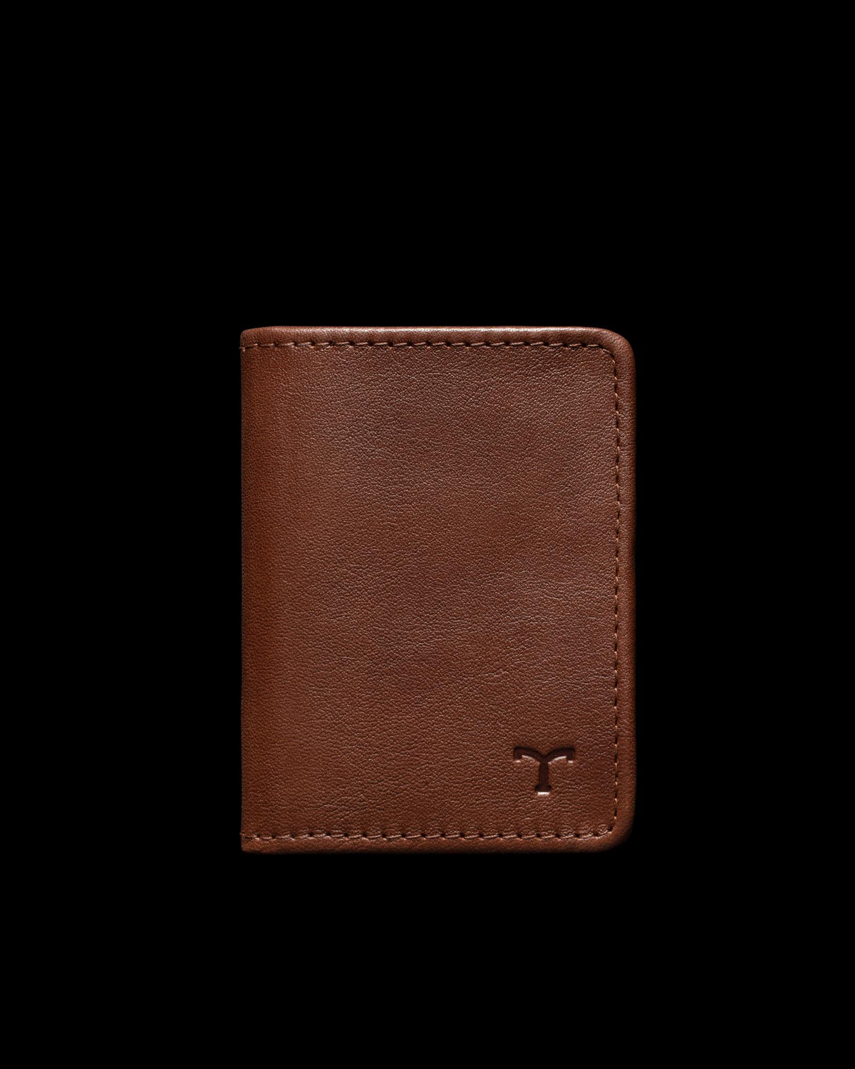 Brown leather wallet with a minimalist design, featuring a small embossed logo on the bottom right corner, set against a black background.