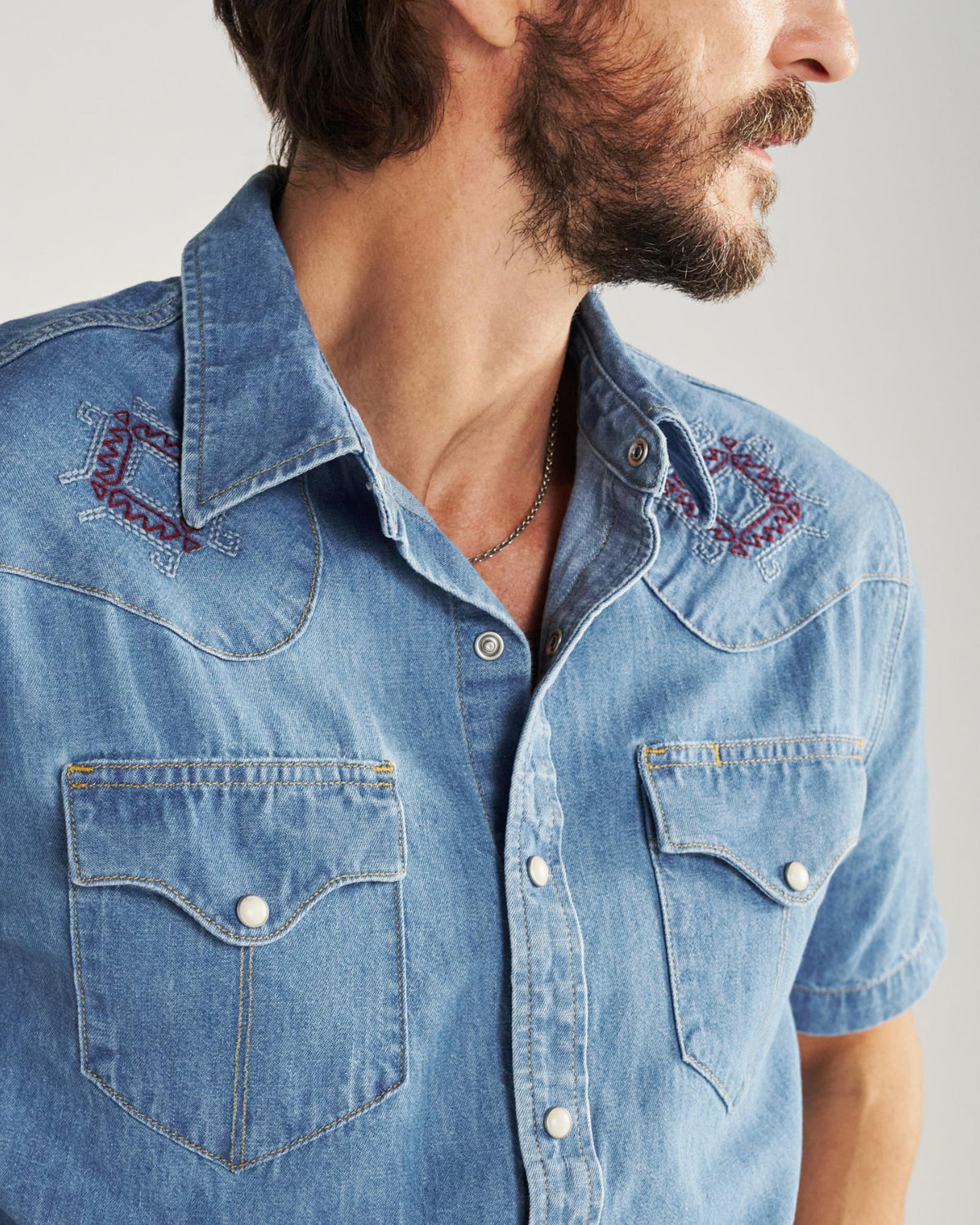 Closeup detail view of Men's Denim Pearl Snap SS - Turquoise / Multi