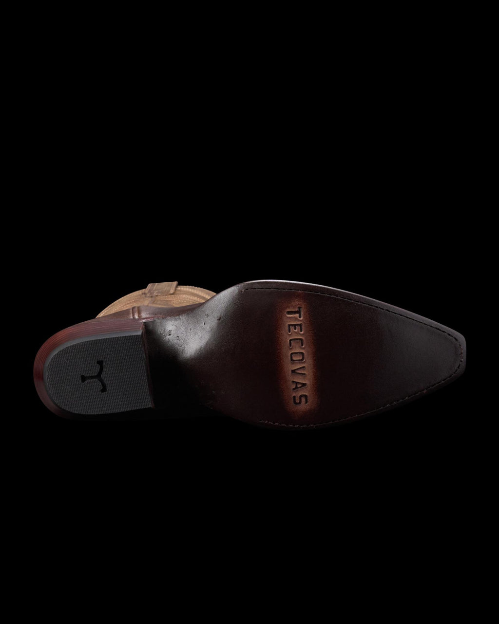 The image shows the underside of a brown cowboy boot with a pointed toe and the brand name "Tecovas" stamped on the sole.