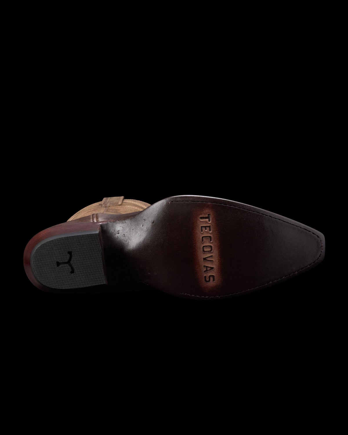 The image shows the underside of a brown cowboy boot with a pointed toe and the brand name "Tecovas" stamped on the sole.