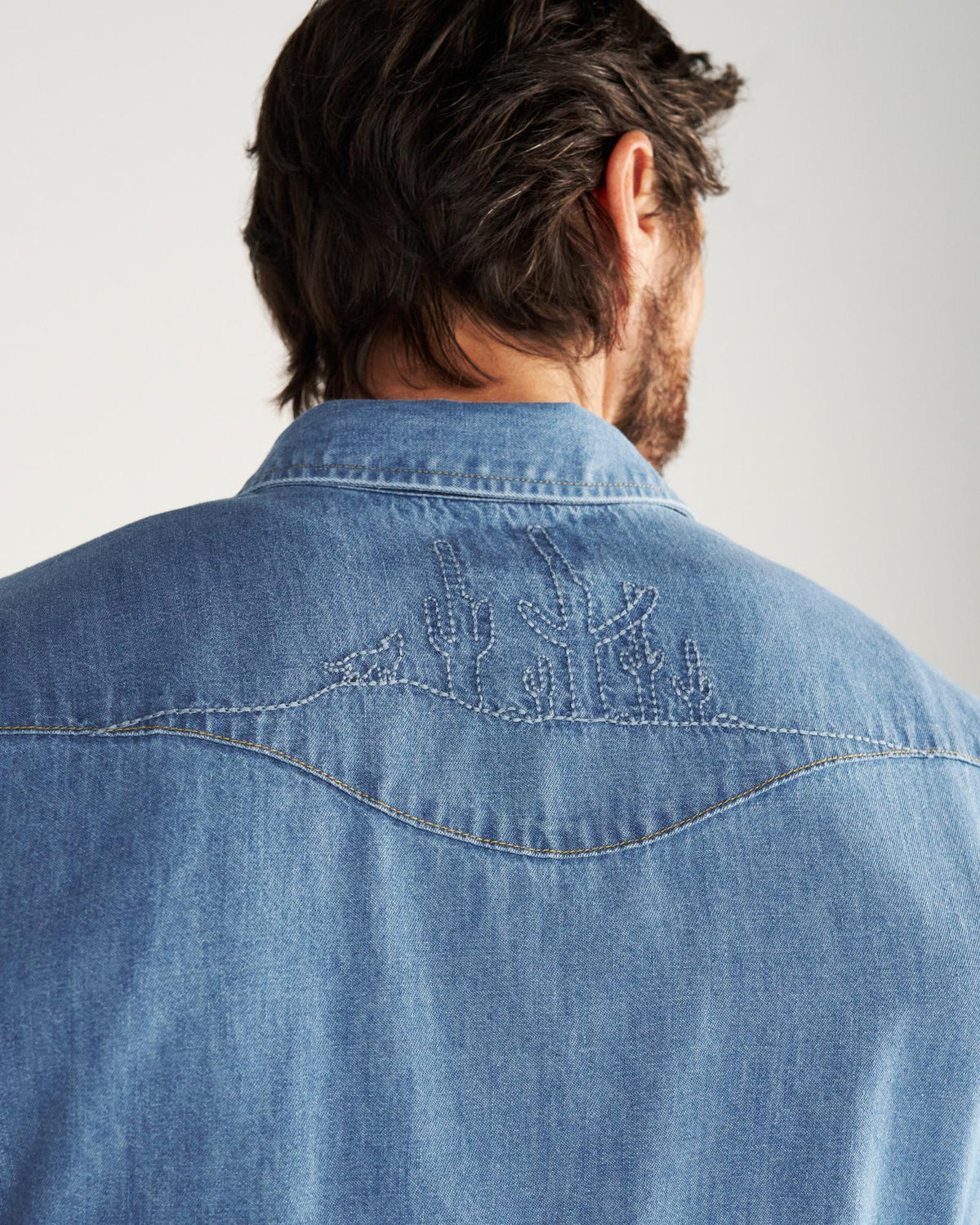 Closeup detail view of Men's Denim Pearl Snap SS - Turquoise / Multi