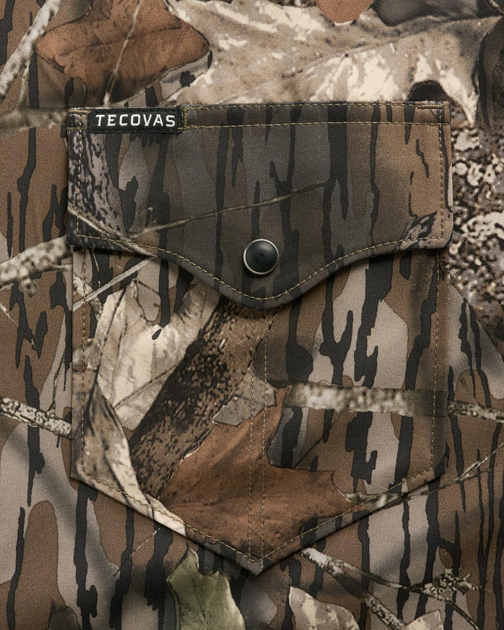 Close-up of a camouflage-patterned shirt pocket with a button flap and a small “Tecovas” label above the pocket.