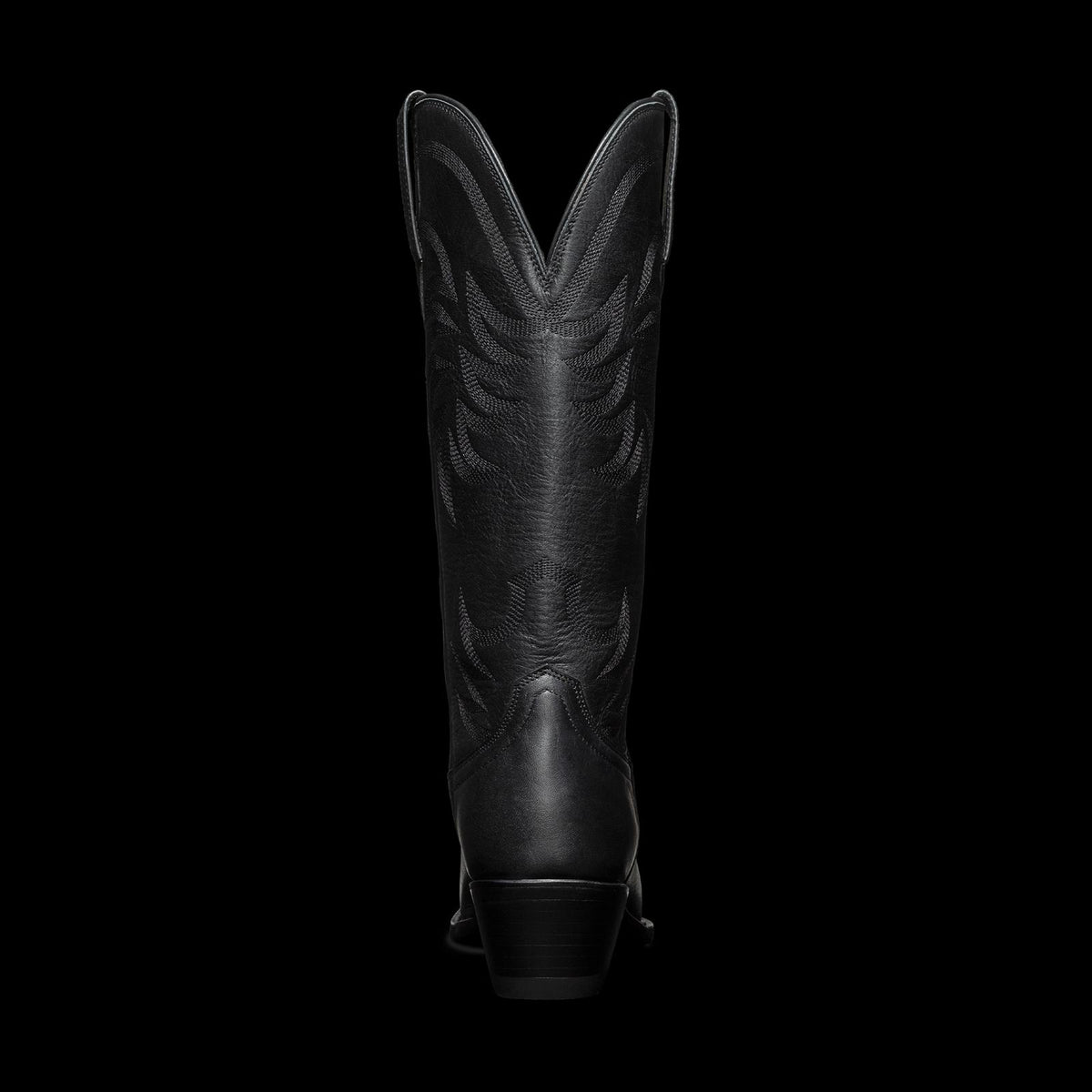 Black cowboy boot with intricate stitching, viewed from the back against a plain white background.