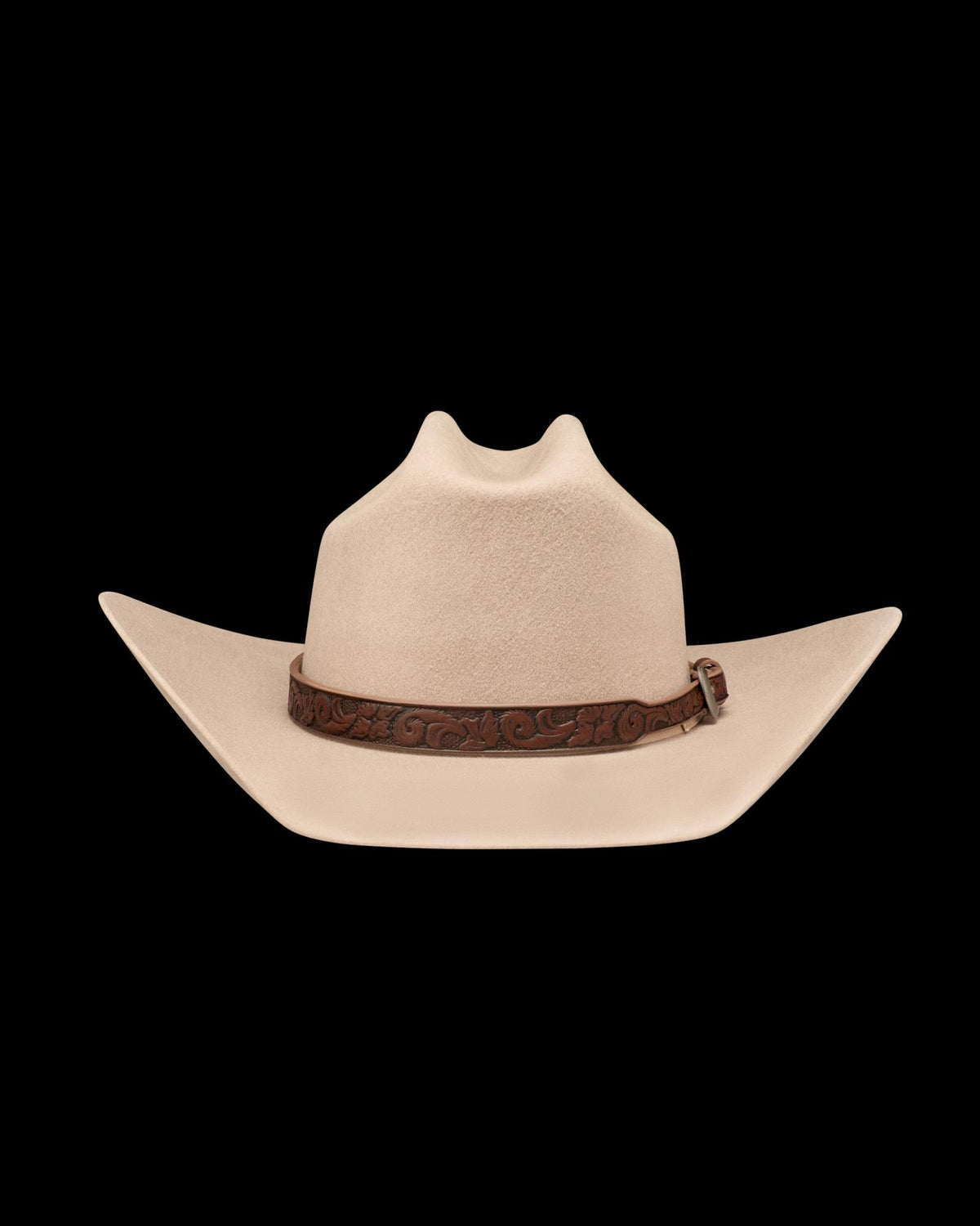 A beige cowboy hat with a wide, upturned brim and a brown tooled leather band, displayed on a plain white background.