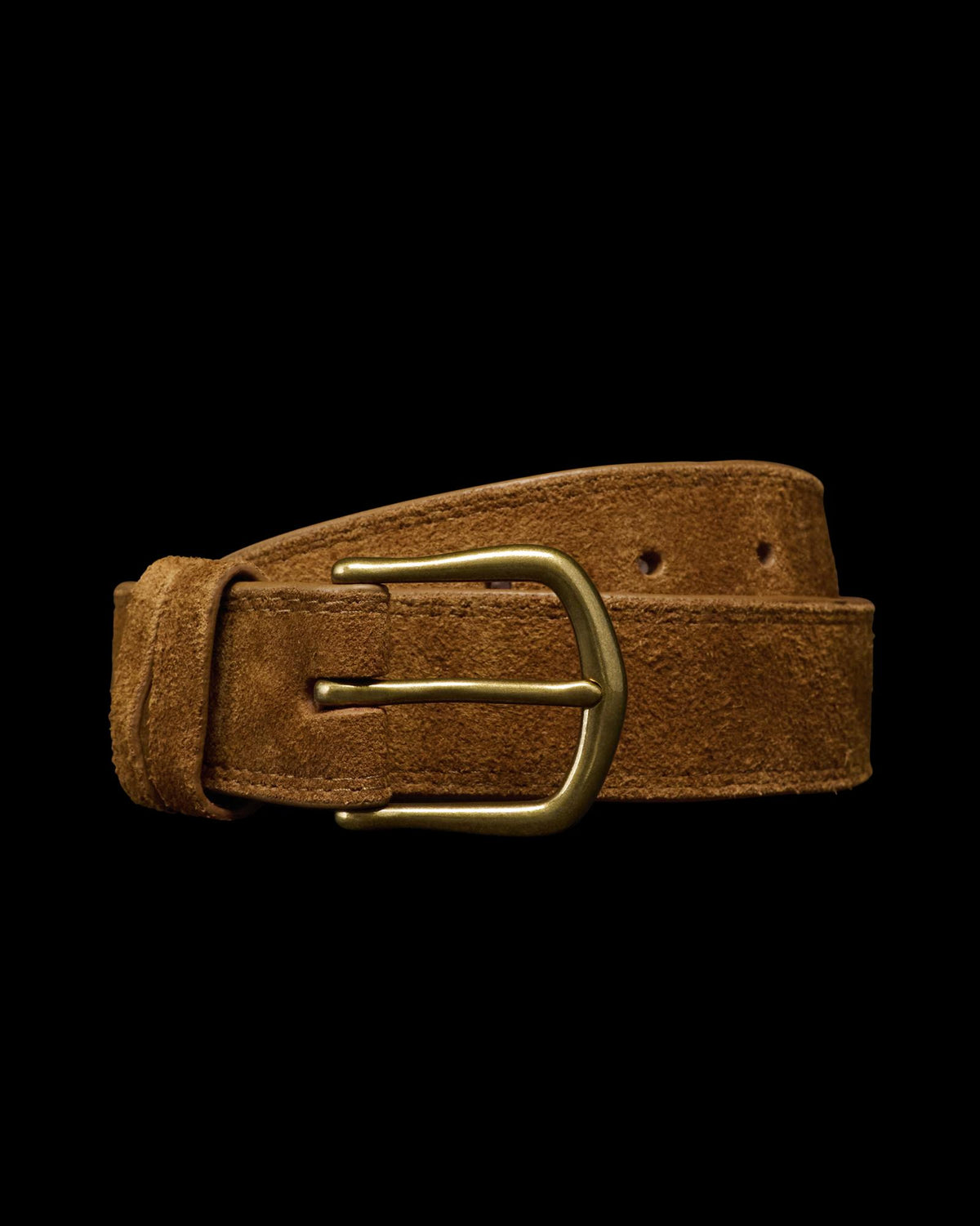 A brown suede belt with a brass buckle is coiled against a plain white background.