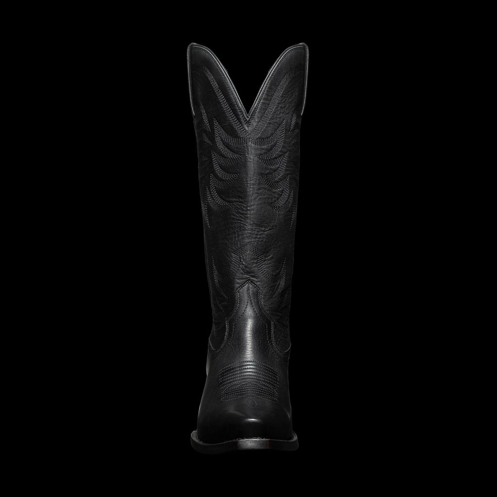 A tall black cowboy boot with stitched patterns, viewed from the front, against a plain background.