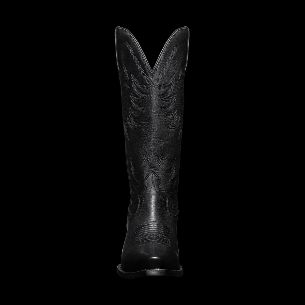 A tall black cowboy boot with stitched patterns, viewed from the front, against a plain background.