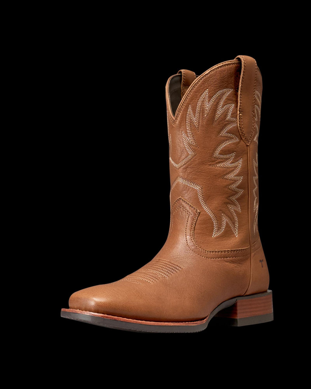 The Dusty in Mesa Goat. A brown leather cowboy boot from The Dusty Goat, featuring white decorative stitching, a low heel, and a pointed toe, shown on a white background.