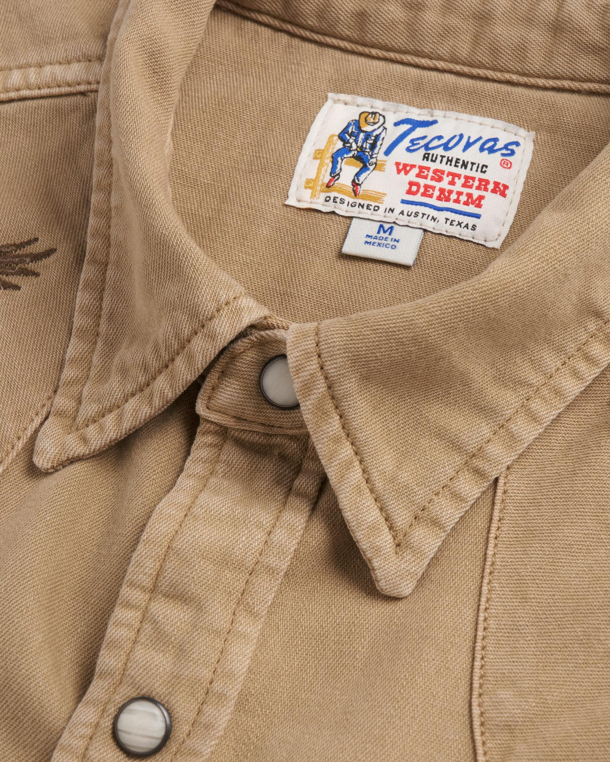Closeup detail view of Men's Denim Pearl Snap SS - Coriander / Multi