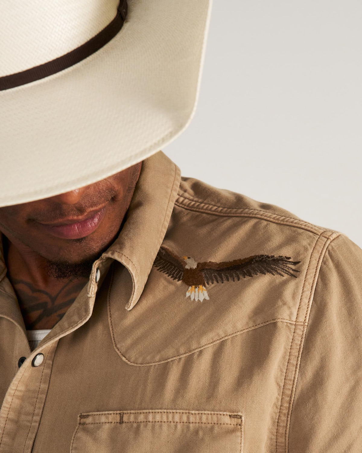 Closeup detail view of Men's Denim Pearl Snap SS - Coriander / Multi