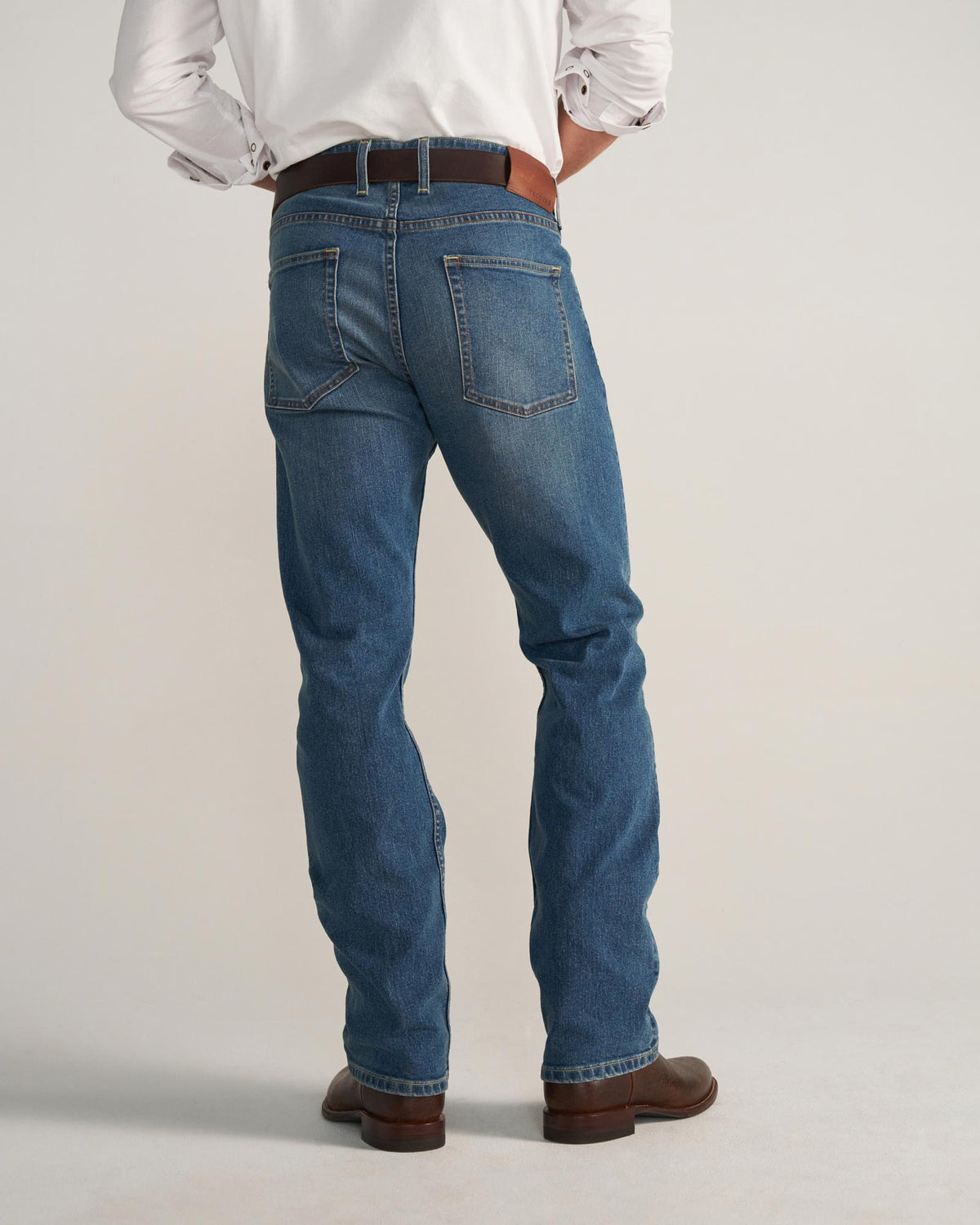 Back view of Men's Slim Straight Stretch Denim - Medium Indigo on model