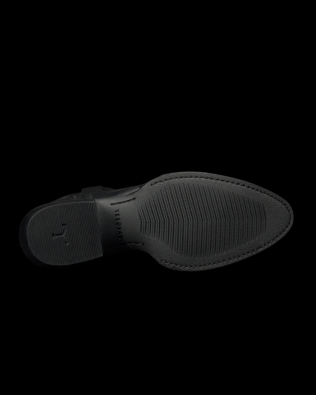 The Britt in Midnight Cowhide. The image shows the black rubber sole of The Britt Cowhide dress shoe, viewed from the bottom, featuring textured grip patterns and subtle branding near the heel.