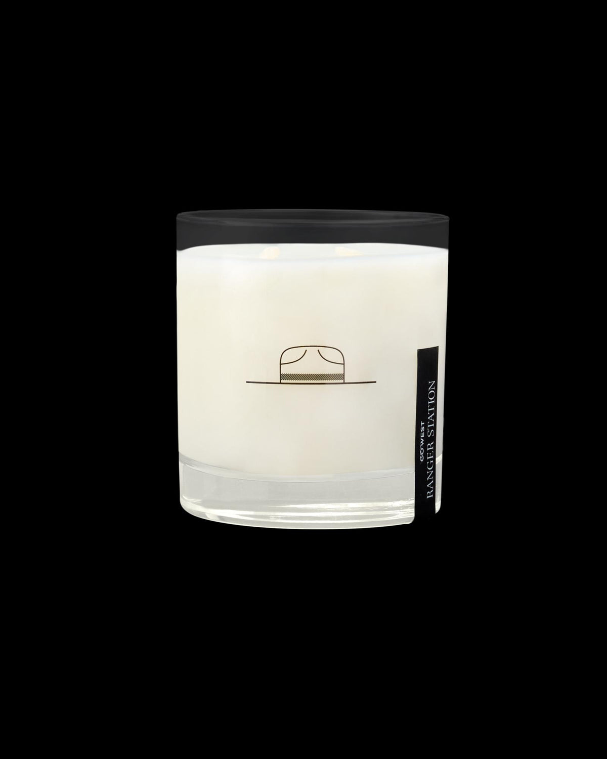 A glass jar candle with a minimalistic design, featuring a small illustration of a hat on the front.