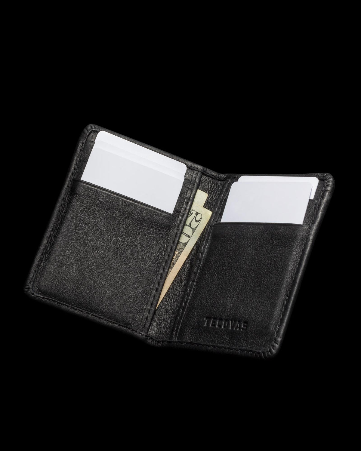 An open black leather wallet with two cards and a folded $20 bill inside.